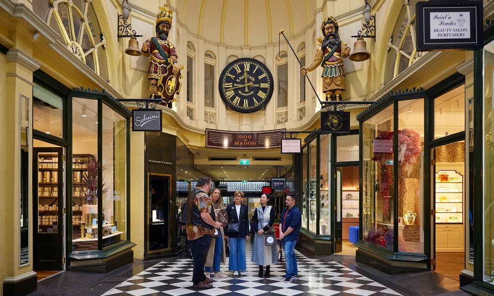 A group of people on a walking tour in an ornate shopping arcade.