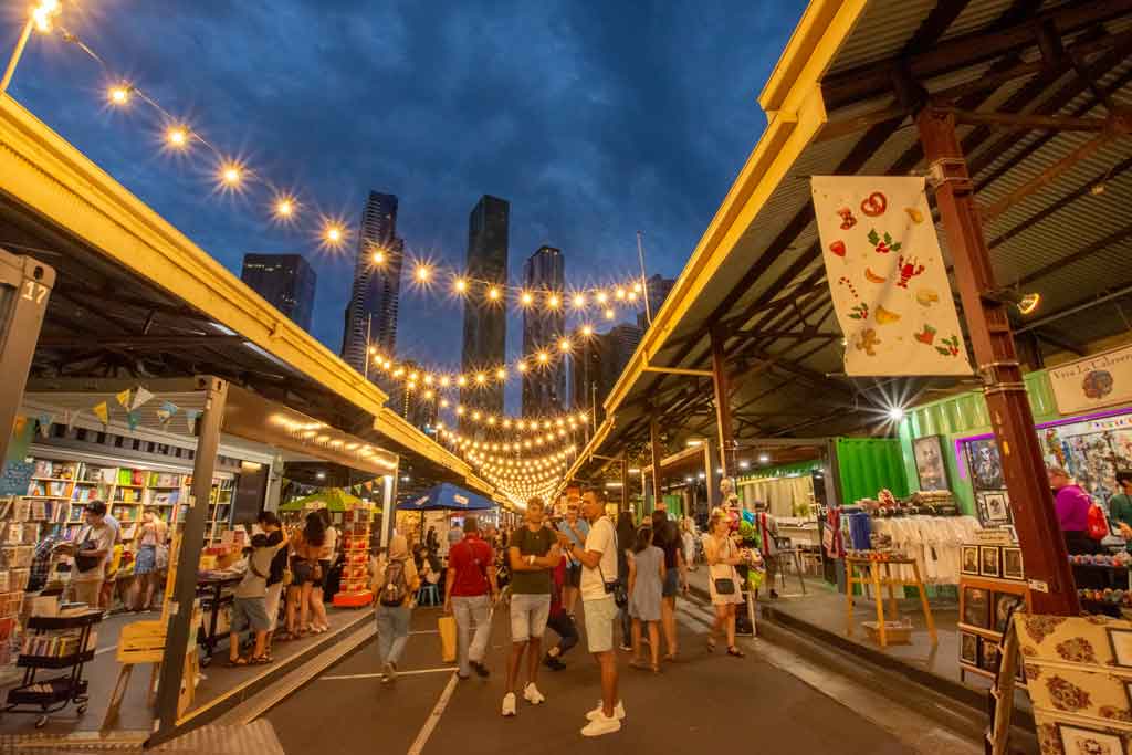 A market at night with sparkling lights hanging over a walkway