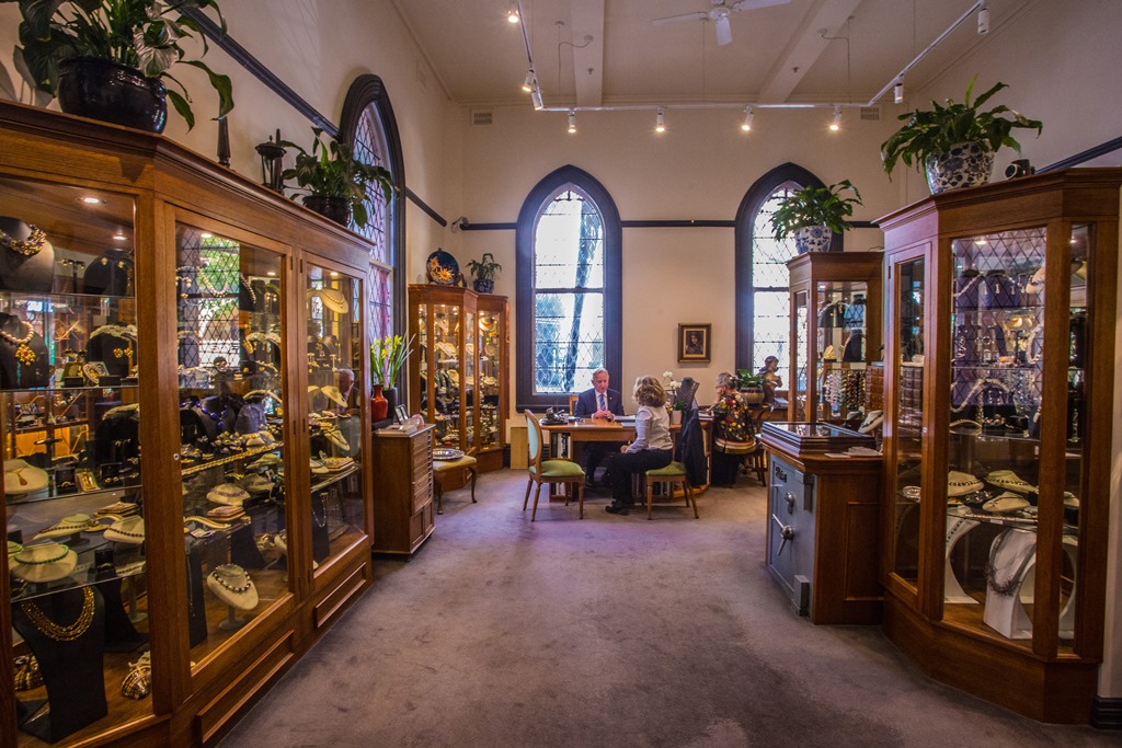 Wide shot of jewellery store in a building attached to church with old fashioned arched windows