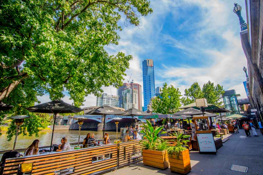 An outdoor beer garden by the water on a sunny day