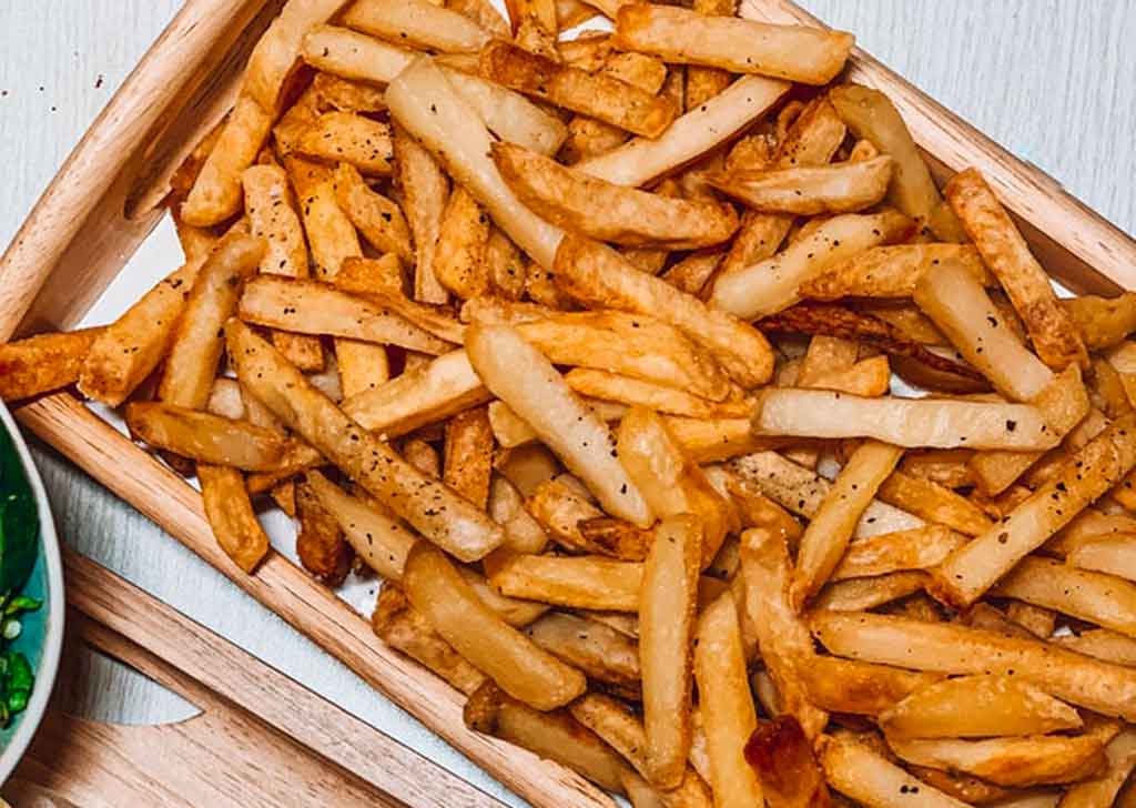 A wooden plate of french fries