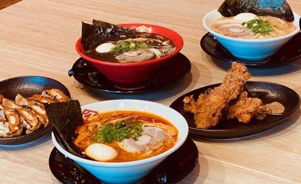 Bowls of ramen and plates of Japanese food on a tabel