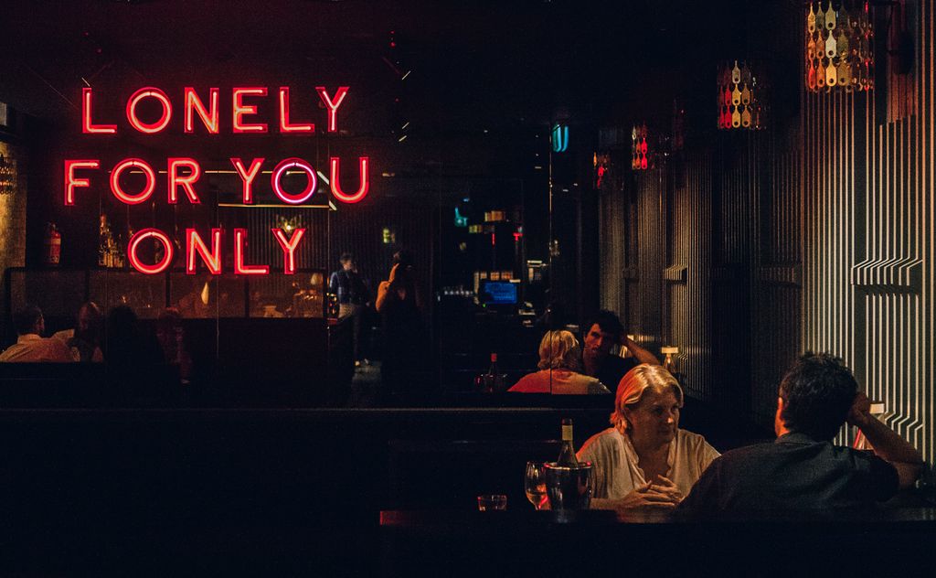 A dark bar with a neon sign on the wall