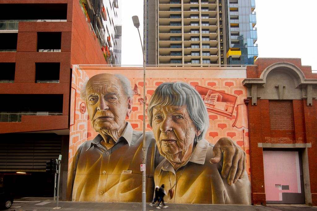 A painting of two older people on the side of a building
