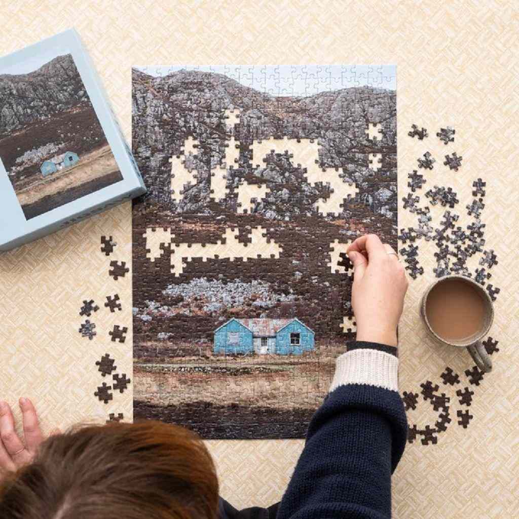 A person leaning over a puzzle