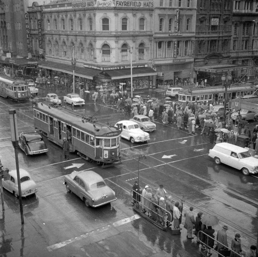 A black and white photo of a rainy street