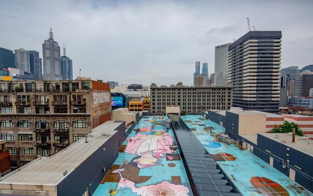 A rooftop view with a blue and pink mural painted on it